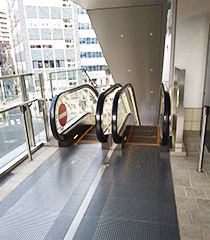 歩道の終点のエスカレータで降りてください。